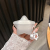 AirPods case with keychain accessory in scene.